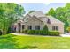 Charming, two-story brick home with blue shutters, landscaped yard, and an American flag at 123 Archbell Point Ln, Mooresville, NC 28117