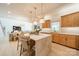 Open kitchen with marble island, wood cabinets, pendant lighting, and view into the living room at 123 Archbell Point Ln, Mooresville, NC 28117