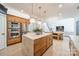 Kitchen featuring a marble island, stainless steel appliances, and access to the dining and living areas at 123 Archbell Point Ln, Mooresville, NC 28117