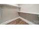 Functional walk-in closet features two shelves with rods and wood-look flooring at 123 Archbell Point Ln, Mooresville, NC 28117