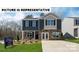 New construction home showcasing a two-story layout, stone accents, and manicured front lawn at 129 Way Cross Ln, Troutman, NC 28166