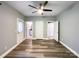 Neutral bedroom featuring wood-look flooring, a ceiling fan, natural light, and multiple access points, creating a versatile space at 1295 Amber Ridge Nw Rd, Concord, NC 28027