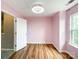 Bedroom featuring hardwood floors, a large window, and light-pink walls at 1295 Amber Ridge Nw Rd, Concord, NC 28027
