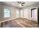 Bright bedroom with wood-look flooring, a ceiling fan, a large window, and a door leading to the outside at 1295 Amber Ridge Nw Rd, Concord, NC 28027