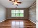 Bedroom featuring hardwood floors, shiplap accent wall, neutral walls, and a fan at 1295 Amber Ridge Nw Rd, Concord, NC 28027