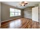 Bright bedroom boasts wood floors, a large window, rustic accent wall, and ceiling fan at 1295 Amber Ridge Nw Rd, Concord, NC 28027
