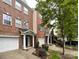 A beautiful brick townhome with a one-car garage, manicured landscaping, and a welcoming entrance, captured on a bright, overcast day at 1295 Amber Ridge Nw Rd, Concord, NC 28027