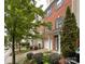 View of a brick townhome with a one-car garage and lush landscaping along the walkway, showcasing the property's curb appeal at 1295 Amber Ridge Nw Rd, Concord, NC 28027