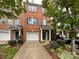 Charming brick townhome featuring a one-car garage, and well-maintained landscaping with a sidewalk leading to the front door at 1295 Amber Ridge Nw Rd, Concord, NC 28027
