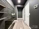 Stylish, modern hallway featuring dark gray walls, wood-look floors, built in shelving, and a bench at 1295 Amber Ridge Nw Rd, Concord, NC 28027