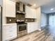 This kitchen features stainless appliances, white cabinets, a subway tile backsplash, and wood-look flooring at 1295 Amber Ridge Nw Rd, Concord, NC 28027