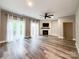 This living room features wood-look floors, neutral walls, a ceiling fan, and a fireplace at 1295 Amber Ridge Nw Rd, Concord, NC 28027