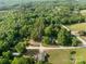 Scenic aerial view of a wooded property with multiple houses, a road, and green fields at 130 Casper Rd, Gold Hill, NC 28071