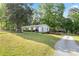 Exterior view of house featuring a gravel driveway, brick landscaping, and white siding at 130 Casper Rd, Gold Hill, NC 28071
