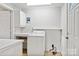 Functional laundry area with white washer, storage shelves, and neutral tones at 130 Casper Rd, Gold Hill, NC 28071
