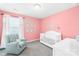 Charming Bedroom with pink walls, white crib, cozy chair, and natural light at 133 W Neel Ranch Rd, Mooresville, NC 28115
