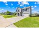 Well-manicured lawn leads to a charming two-story gray home with an attached two-car garage at 133 W Neel Ranch Rd, Mooresville, NC 28115