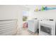 Bright laundry room features white washer and dryer, storage shelves and a window at 133 W Neel Ranch Rd, Mooresville, NC 28115