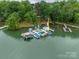 Stunning aerial view of boat docks nestled in a serene lake setting surrounded by lush trees at 134 Lawrence Tee Ln, Mooresville, NC 28117