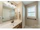 Neutral bathroom with wooden vanity, white marble countertop, modern lighting, and shuttered window at 134 Lawrence Tee Ln, Mooresville, NC 28117