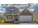 Charming two-story home featuring a covered porch, a two-car garage, and landscaped yard at 135 Way Cross Ln, Troutman, NC 28166