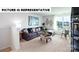 A spacious living room with modern decor, a large sectional sofa, desk, and stylish shelving at 135 Way Cross Ln, Troutman, NC 28166