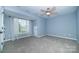 Light filled bedroom with ceiling fan, window and neutral carpet at 15406 Pepperwood Ct, Huntersville, NC 28078