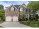 Charming brick home with a two-car garage and a bright blue front door at 15406 Pepperwood Ct, Huntersville, NC 28078