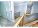 Bright hallway with neutral carpet, wood railing, and light blue walls leads to upstairs bedrooms and living areas at 15406 Pepperwood Ct, Huntersville, NC 28078