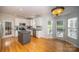Bright eat-in kitchen features granite counters, stainless appliances, gray island, and double doors to outdoor at 15406 Pepperwood Ct, Huntersville, NC 28078