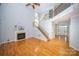 Open living room with gas fireplace, soaring ceilings, wood floors, and staircase to second level at 15406 Pepperwood Ct, Huntersville, NC 28078