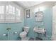 This bathroom has light blue tile, an antique sink, and a window with shutters at 222 E Carter St, Lincolnton, NC 28092