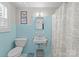 Vintage bathroom featuring light blue tile, an antique sink, and a window with shutters at 222 E Carter St, Lincolnton, NC 28092