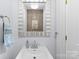 Modern powder room with white vanity, brushed nickel faucet, and decorative mirror at 222 E Carter St, Lincolnton, NC 28092