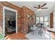 Cozy sunroom with brick wall, ceiling fan, tile floor, and comfortable seating area at 222 E Carter St, Lincolnton, NC 28092