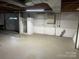 Unfinished basement space with concrete floor and white painted cinder block walls at 224 Locust Ave, Locust, NC 28097