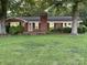 Charming brick home with a well-manicured lawn and mature trees in a quiet neighborhood at 224 Locust Ave, Locust, NC 28097