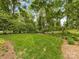 Spacious backyard with well-manicured lawn and mature trees, ideal for outdoor activities and entertaining at 2611 Forest Dr, Charlotte, NC 28211