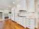 Bright kitchen features white cabinets, stainless steel appliances, and hardwood floors at 2611 Forest Dr, Charlotte, NC 28211