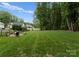 Expansive backyard with lush green lawn, mature trees, fire pit and seating area, ideal for outdoor enjoyment at 2646 Lee Lawing Rd, Lincolnton, NC 28092