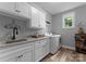 Laundry room featuring white cabinets, granite countertops, a utility sink, and a window at 2646 Lee Lawing Rd, Lincolnton, NC 28092