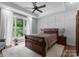 Spacious main bedroom featuring a large bed, wood floors, tray ceiling and natural light at 2646 Lee Lawing Rd, Lincolnton, NC 28092