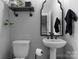 Powder room featuring a pedestal sink, toilet, and decorative mirror at 2646 Lee Lawing Rd, Lincolnton, NC 28092