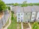 Aerial view of a townhome complex with colorful facades, manicured lawns, and tree-lined streets at 2907 W Trade St, Charlotte, NC 28208