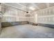 This garage features concrete floors, white walls, and an unfinished ceiling with exposed beams at 2907 W Trade St, Charlotte, NC 28208