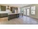 Open kitchen and dining area with gray cabinets, stainless appliances, a large island, and natural light at 2907 W Trade St, Charlotte, NC 28208