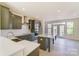 Open-concept kitchen featuring a large island with seating, gray cabinets, and stainless steel appliances at 2907 W Trade St, Charlotte, NC 28208