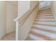 A staircase with light wood steps and white risers, complemented by a wooden handrail against a neutral wall at 2907 W Trade St, Charlotte, NC 28208