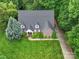 Aerial view of the brick home showcasing mature landscaping, verdant lawn, and private driveway at 3015 Hamptonbrook Dr, Gastonia, NC 28056
