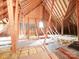 Unfinished attic with exposed wood beams, insulation, and natural light at 3015 Hamptonbrook Dr, Gastonia, NC 28056